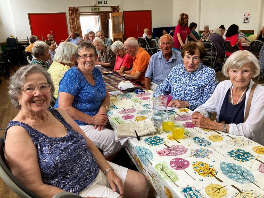 People attending a Food and Friendship lunch around a table 