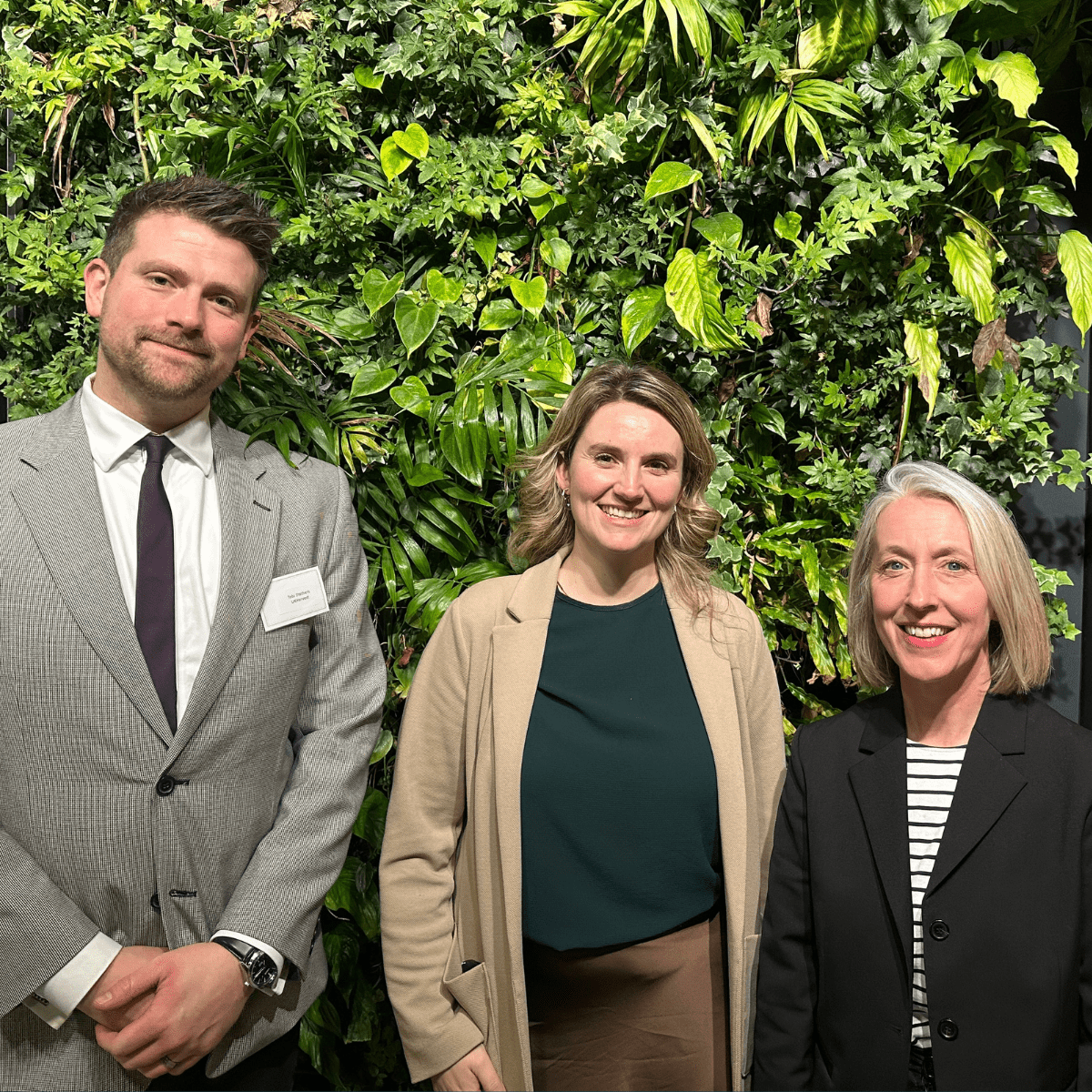 Hannah Clay, Jess Brown-Fuller and Tobias Stathers in front of a green wall