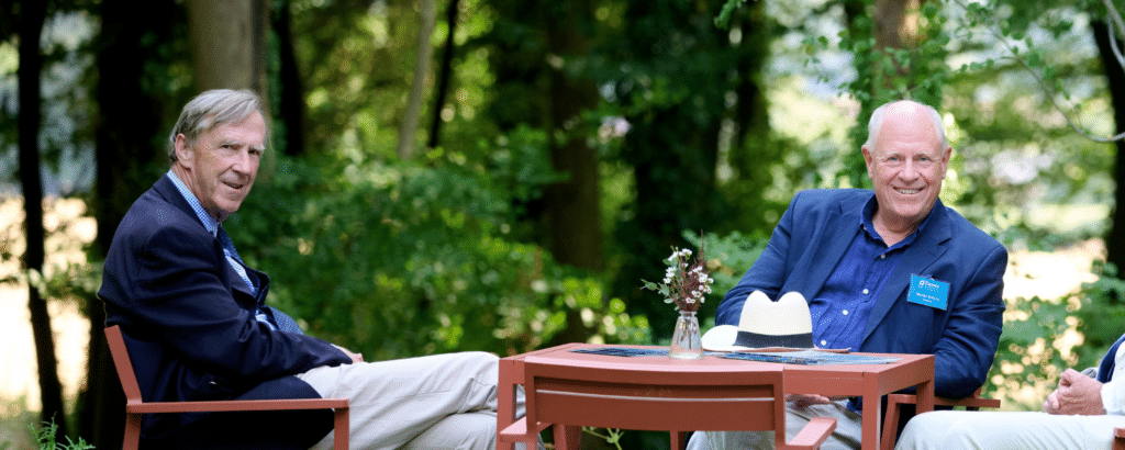 two men sitting at a talk talking outside